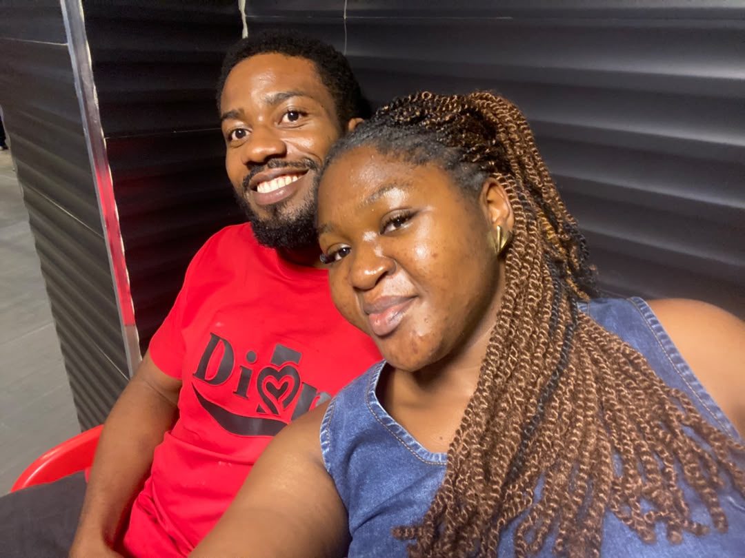 Nnenna and Chukwuma smiling together, Chukwuma in a red tee