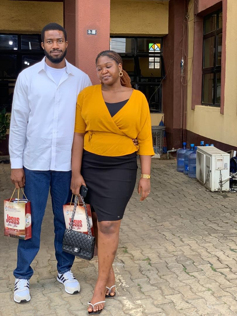 Chukwuma and Nnenna standing together holding gift bags