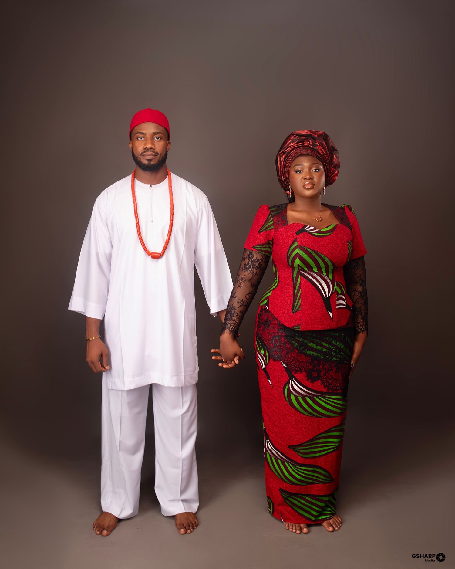 Nnenna and Chukwuma standing hand in hand in Igba Nkwu attire