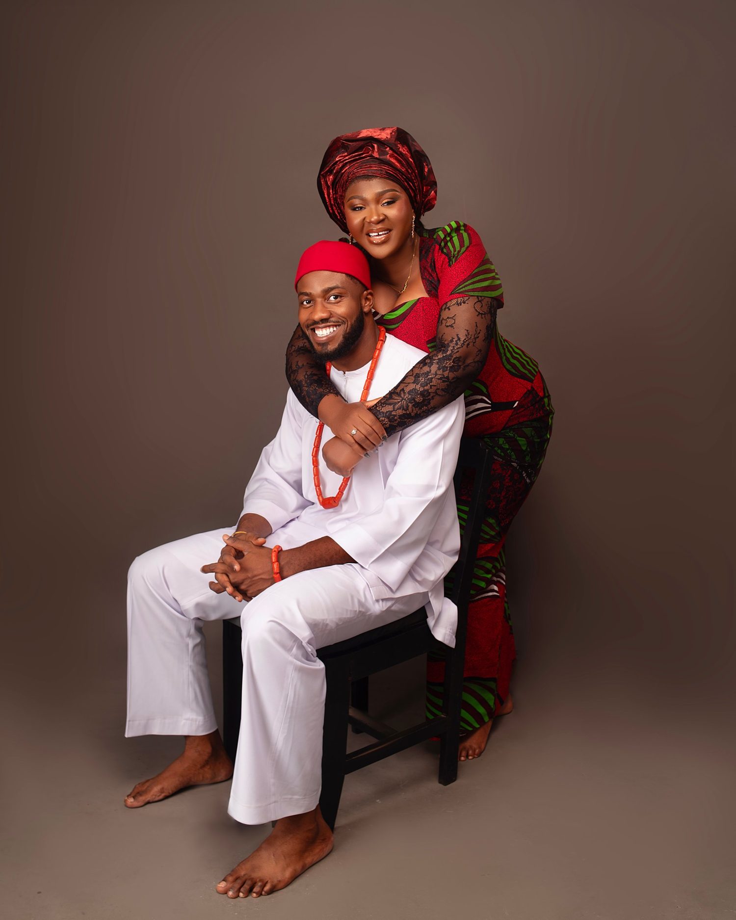 Nnenna embracing a smiling Chukwuma from behind in Igba Nkwu attire