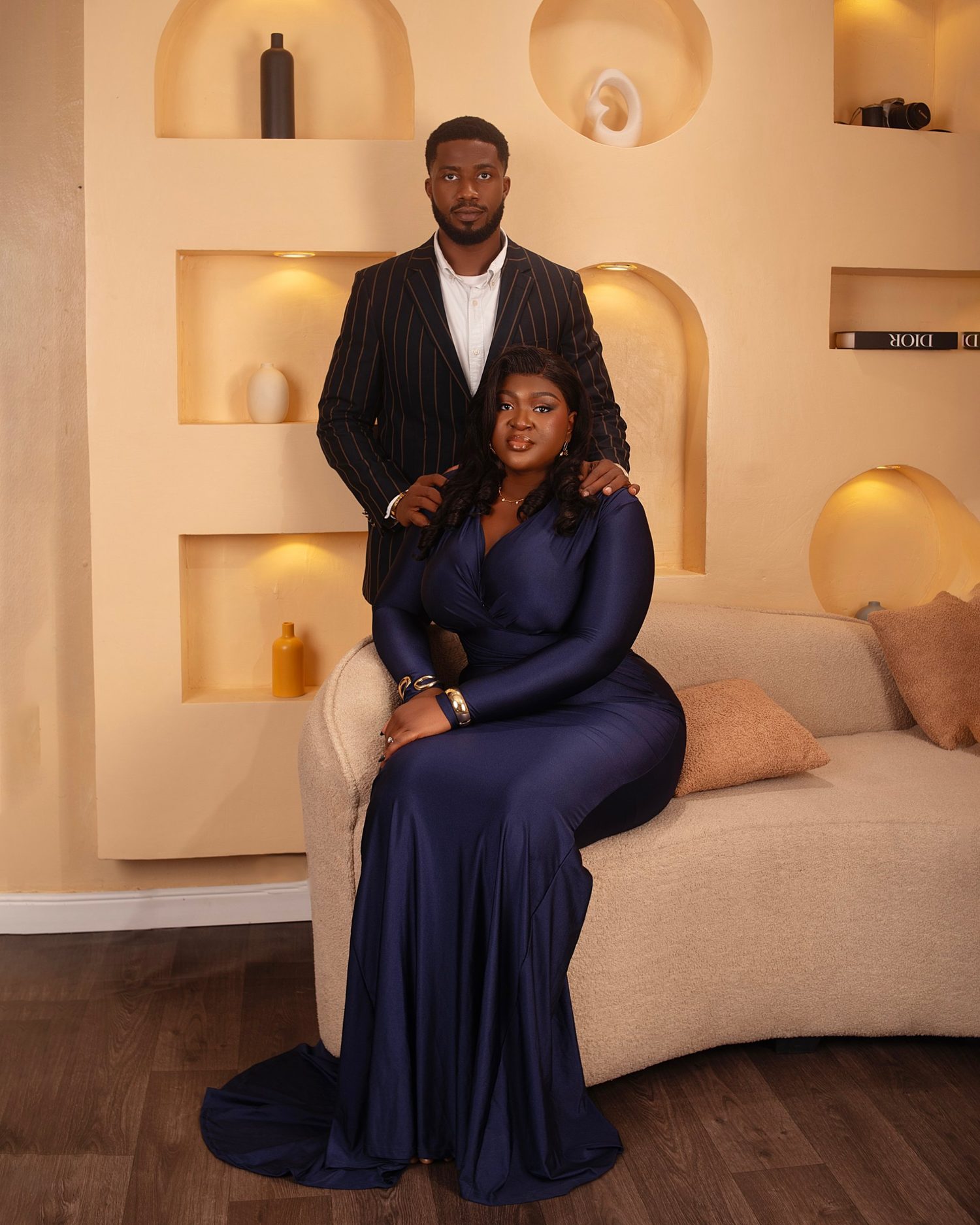 Chukwuma standing behind a seated Nnenna in a navy gown