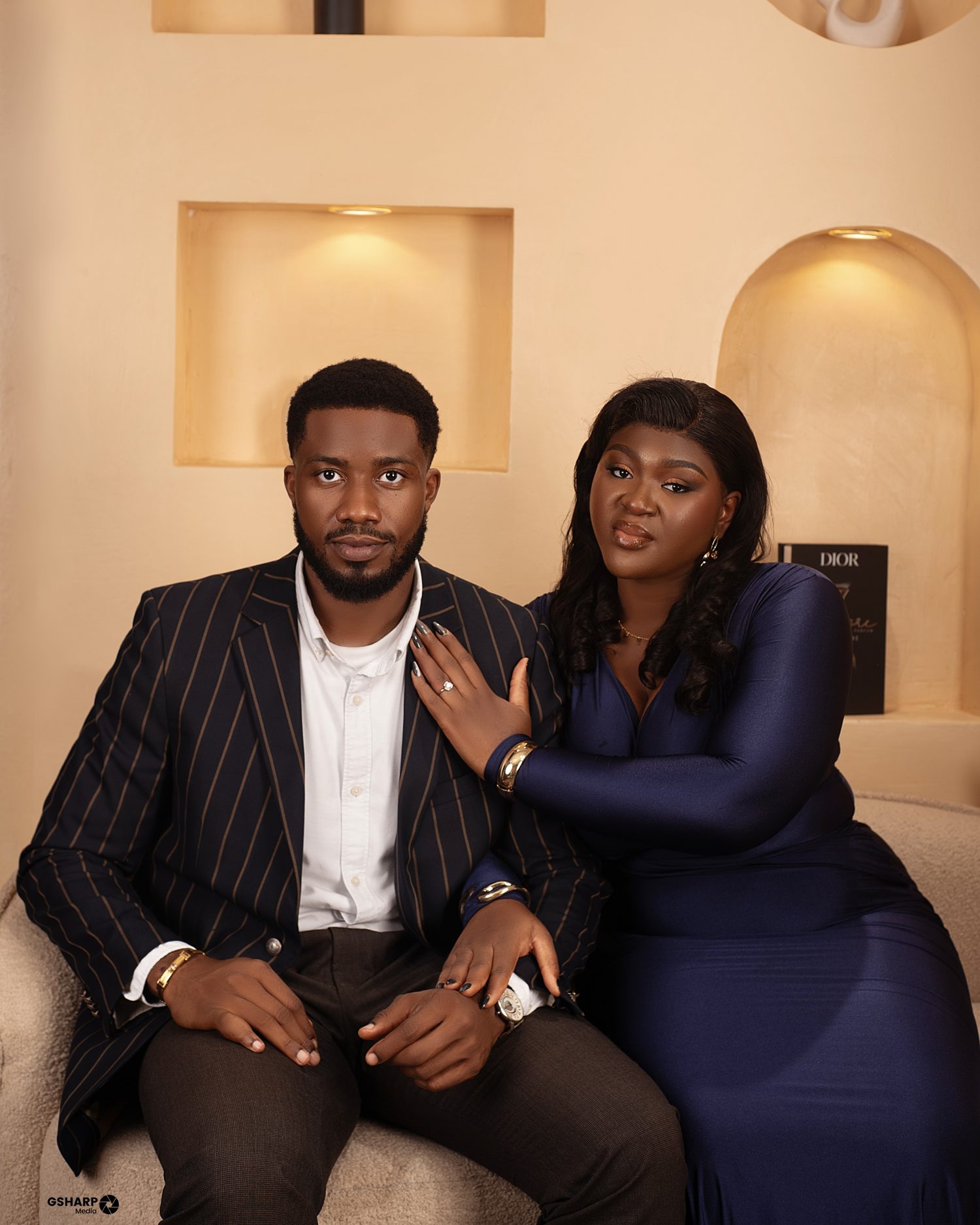 Chukwuma seated on a sofa with Nnenna’s hand on his shoulder